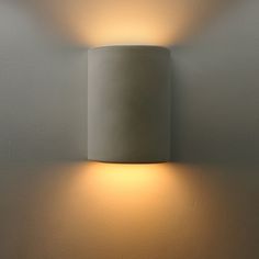 a wall light that is on the side of a wall with a white lamp in front of it