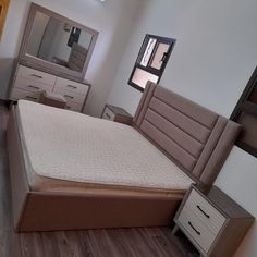 a bedroom with a bed, dressers and mirror in it's center area