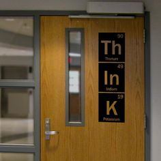 the door to an office building is labeled with different element name and symbol, including k