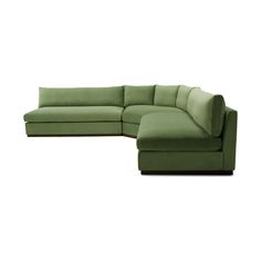 a green sectional couch sitting on top of a white floor