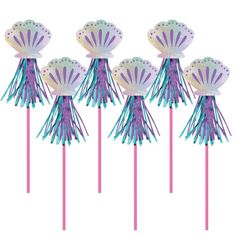 six purple and blue paper decorations on top of pink straws in the shape of seashells