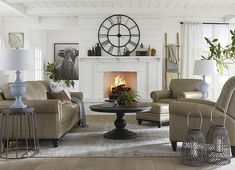 a living room filled with furniture and a fire place under a clock mounted on the wall