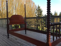 a wooden bed sitting on top of a wooden deck