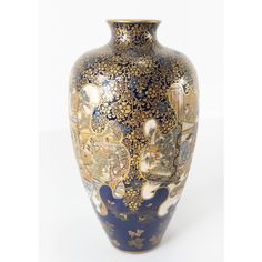 a blue and gold vase sitting on top of a white table