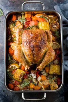 a roasted chicken in a roasting pan with vegetables