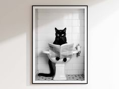 a black cat sitting on top of a toilet reading a newspaper in a white bathroom