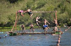 some people are playing in the water while others watch from behind a net with nets on it