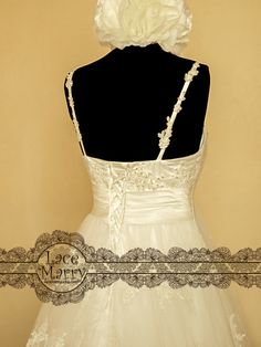 the back of a wedding dress with a flower on it's head and neckline