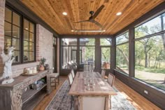 a dining room with wooden ceiling and large windows