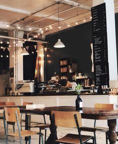 the interior of a restaurant with tables, chairs and menus hanging from the ceiling