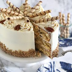 there is a cake with white frosting and pecans on the side, cut in half