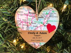 a heart shaped ornament hanging from a christmas tree with a map on it