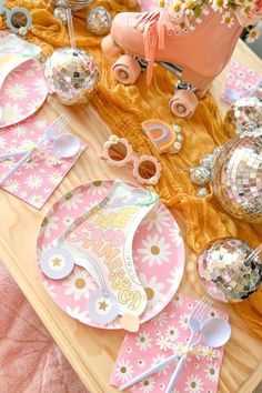 a table topped with lots of pink and gold decorations on top of a wooden table