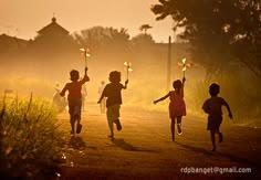 four children running down the road with windmills in their hands at sunset or dawn