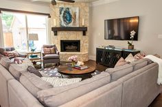 a living room filled with furniture and a flat screen tv mounted on the wall above a fireplace