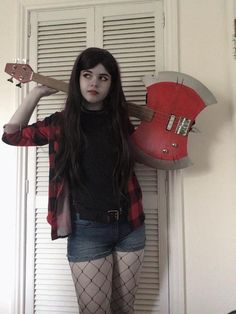 a woman in fishnet stockings and tights holding an electric guitar over her head