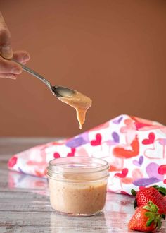 a spoon full of peanut butter and some strawberries