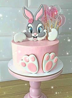 a pink cake decorated with an image of a rabbit