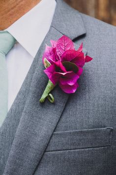 a man in a suit with a pink flower on his lapel