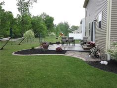 a back yard with landscaping and lawn furniture