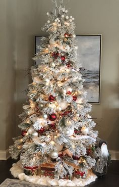 a white christmas tree with red and silver ornaments