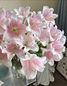 a vase filled with pink flowers on top of a table