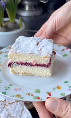 someone is holding a piece of cake on a plate