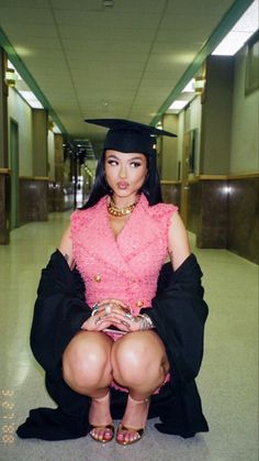 a woman sitting on the ground wearing a graduation cap and gown