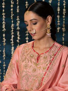 "Jashn-E-Ulfat" - a collection of ensembles that evoke a sense of majestic opulence and modern royalty. Suffused with deep rich hues set on plush cotton silk enhanced with remarkable craftsmanship like Marodi, Mirror and Zardozi embroidery, each ensemble has a romantic and feminine charm of its own collection. This set of 3 consists of a Kurta, Salwar and Dupatta. Kurta: This dainty peach chanderi silk kurta is enhanced with handcrafted zardozi, sitara and zardozi jaal work on the neck, buttas o