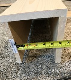 a wooden table with a measuring tape on the floor next to it and a ruler in front of it