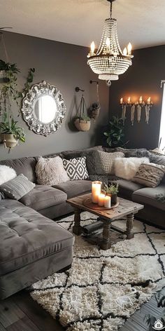 a living room filled with furniture and a chandelier hanging above the couches