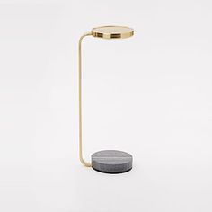 a table lamp with a marble base and a gold plated metal arm, on a white background