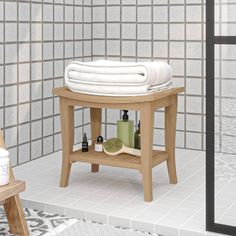 a wooden stand with towels and soaps on it in front of a tiled wall