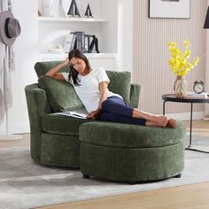 a woman sitting in a green chair with her feet up on the armrests