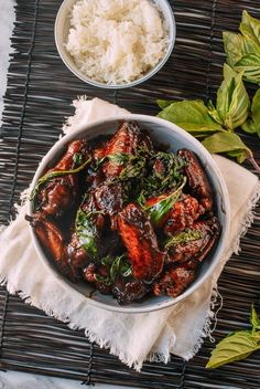 a bowl filled with meat and vegetables next to rice