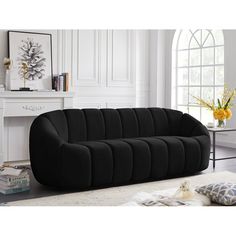 a black couch sitting on top of a white rug