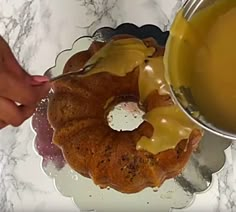 someone is dipping honey into a bundt cake