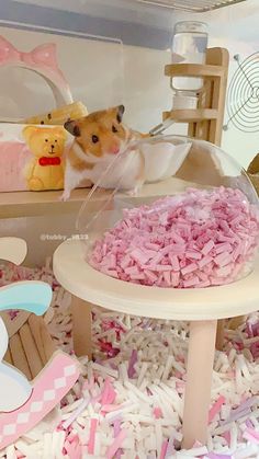 a hamster in a toy house with pink and white sprinkles on the floor