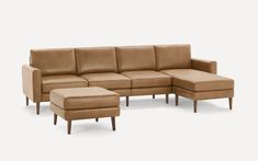 a brown leather couch and ottoman with wooden legs