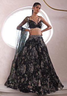 Unveil the epitome of sangeet sophistication with the Black Embroidered Lehenga. Crafted for the modern bride who seeks a blend of tradition and contemporary flair, this organza marvel glimmers with an embroidery of floral and paisley motifs. The lightweight yet voluminous lehenga is teamed with a modern uniquely cut strappy blouse. A sheer dupatta drapes gracefully, completing a look that's as enchanting as the night itself. Perfect for making your sangeet or cocktail night unforgettable Composition : Lehenga, Blouse, Dupatta - Organza Care: Dry Clean Only and Vacuum Storage This product can be customized for sleeves, length of blouse and neckline Delivery : 4-6 weeks as the product is hand crafted. Check Size Guide or choose MySize for free customisation (All Sizes above XL can be made a Astha Narang, Mahima Mahajan, Lehenga Style Saree, Indian Bridesmaid Dresses, Black Lehenga, Cocktail Night, Lehenga Style, Embroidered Lehenga, Ruffled Blouse