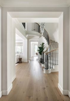 an empty hallway with wooden floors and white walls