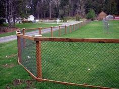 a wooden fence in the middle of a grassy field