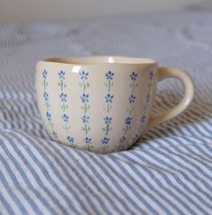 a white cup with blue flowers on it