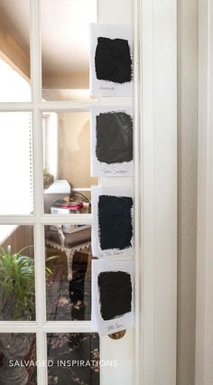 some black paint is on the wall in front of an open door and there are four different colors