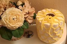 there are two cakes on the sink with flowers next to each other, one is yellow