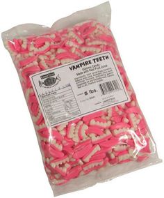 a bag of pink and white candies with vampire teeth on the side, in plastic packaging