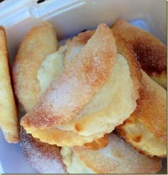 some sugared pastries are in a plastic container