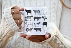 a woman holding a coffee mug with cows on it