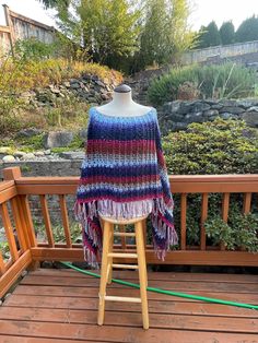 This beautiful warm crochet  poncho  with fringe is a good addition to many outfits from dress-up to casual wear.  The variegated colors in the yarn really compliment each other and the stitch used gives the texture that makes the colors stand out. The fringe adds a bit of length. If you prefer the poncho without fringe please let me know I can make the adjustments.  You can wear this poncho as a triangle poncho or square poncho.   **This poncho is made and ready to ship.**.  This is a  one size fits most. Measurements are width about 36 inches and the length is about 37 inches.   If you have a color or a different size that you prefer, I would be happy to see if the yarn is available and go from there as a custom order.  This poncho can be washed on gentle cycle with cold water no spin an Casual One Size Poncho With Fringe, Casual One-size Poncho With Fringe, Bohemian Knit Poncho With Fringe, Blue Fringe Poncho One Size, Blue One-size Poncho With Fringe, One Size Blue Poncho With Fringe, Winter Multicolor Poncho With Tassels, Multicolor Tassel Poncho For Winter, Fall Multicolor Fringe Shawl