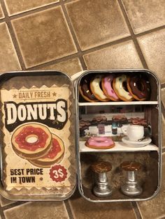 two tins filled with donuts on top of a tiled floor